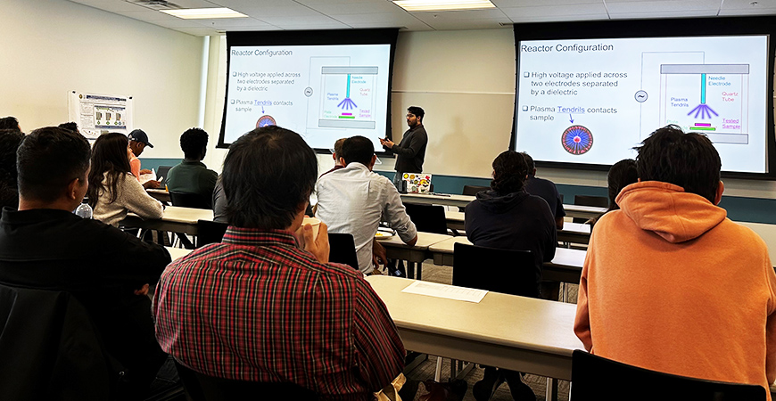 graduate student wearing black presenting to the group